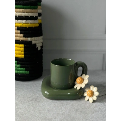 Dark green ceramic cup with attached saucer